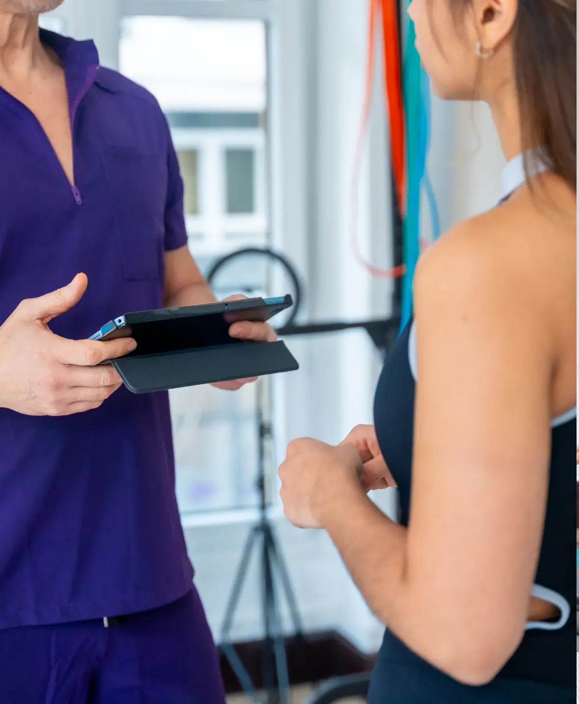Medical professional explaining the risks and considerations of silicone buttock implant surgery to a female patient.